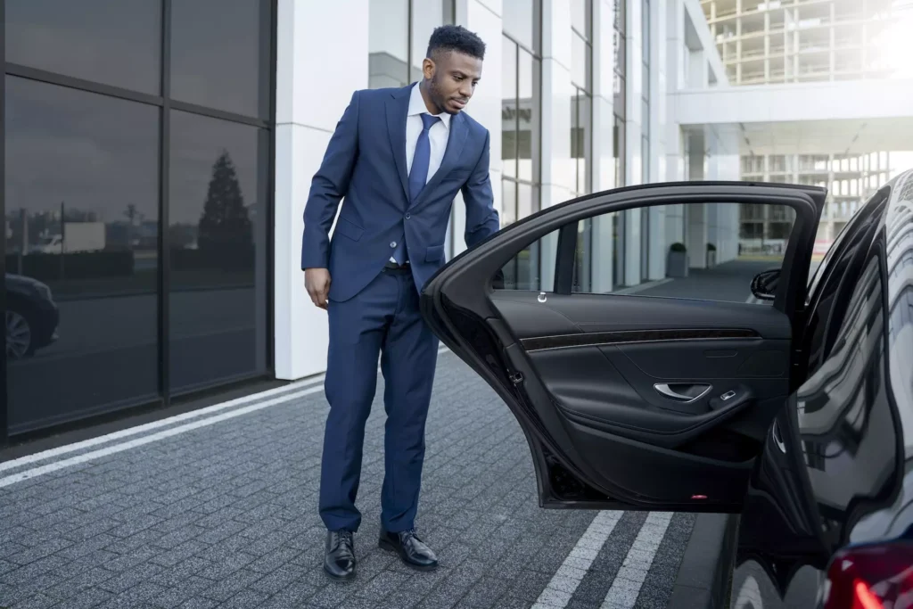 Chauffeur privée qui ouvre la porte à des voyageurs pour aller à Interlaken